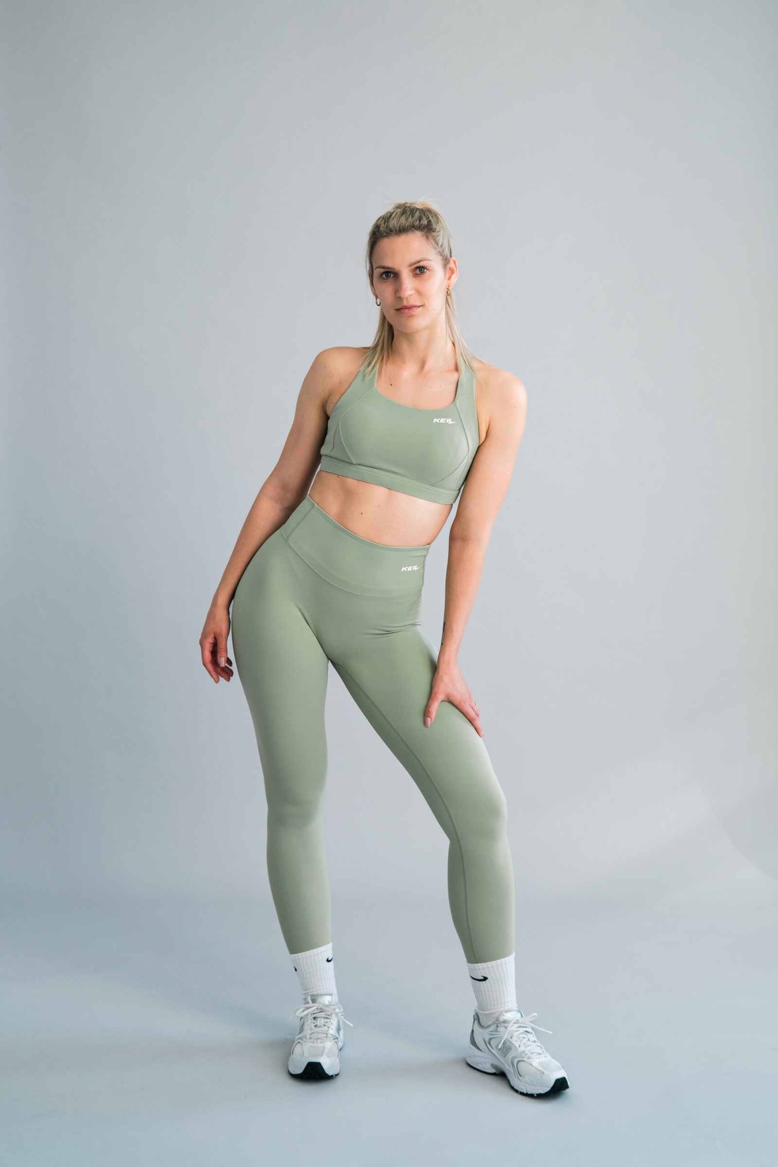 Sieviete pozē ar KEIL athletic Green Harmony legingiem - joga un fitness